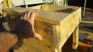 When attaching your new top piece to the frame, hold a piece of timber on top as shown. This makes sure that your new slat won't get in the way of the lid later.